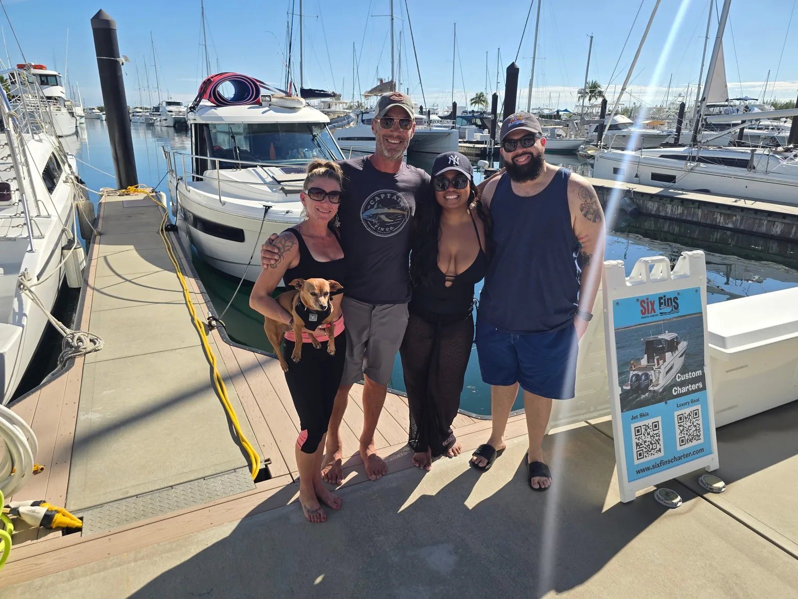 Six Fins charter guests and their dog on the dock at a Key West marina before a private charter