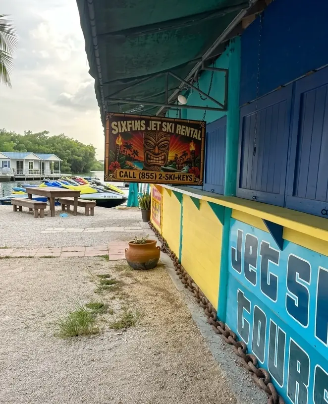 Six Fins Jet Ski Rental tiki booth sign and Yamaha WaveRunners at Hurricane Hole Marina in Key West, Florida